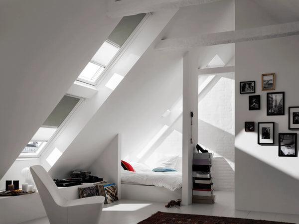 Wit plisségordijn met verduisteringspaneel op een VELUX dakraam in zolderkamer