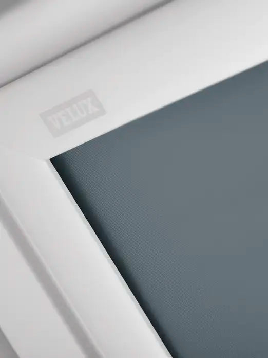 VELUX DKL MK06 verduisterend rolgordijn — close-up productfoto, donkergrijs blackout-doek in wit dakraam-frame