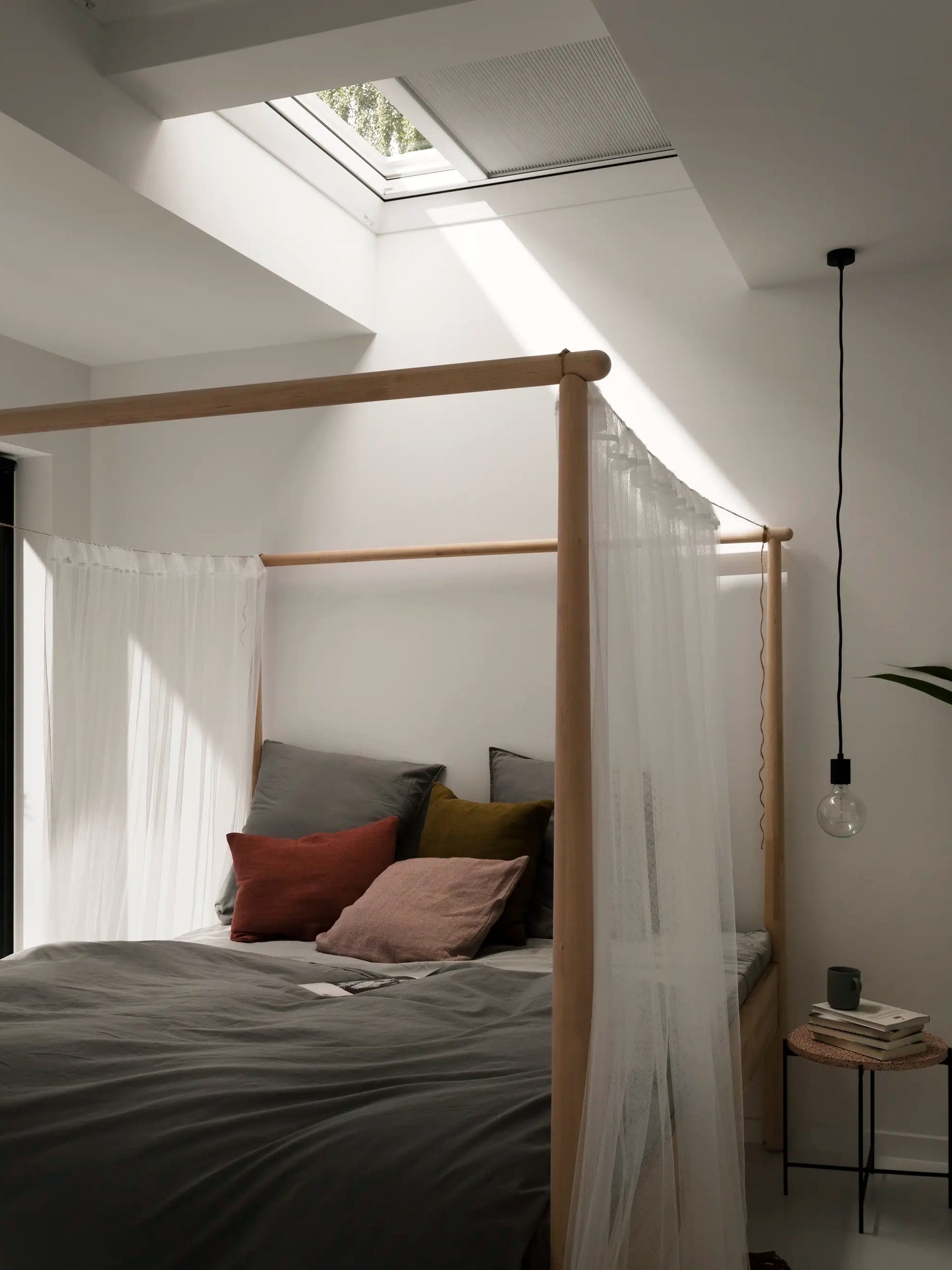 Elektrisch verduisterend rolgordijn VELUX DML/DSL in moderne zolderkamer