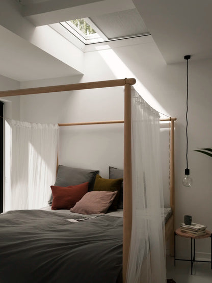 Elektrisch verduisterend rolgordijn VELUX DML/DSL in moderne zolderkamer