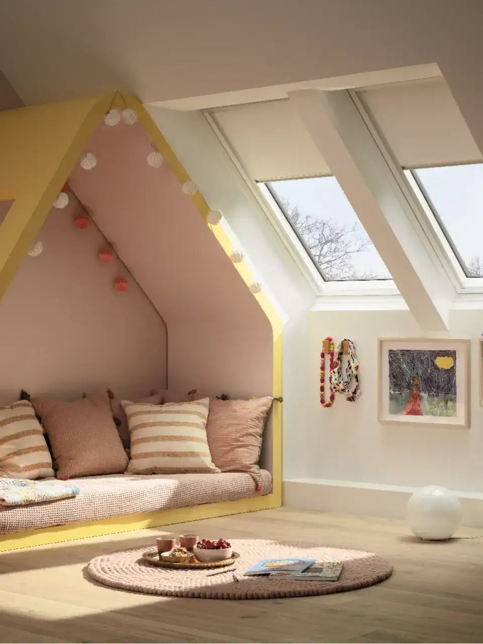 Attic kids room with sloped ceiling and VELUX roof windows, cozy reading nook.